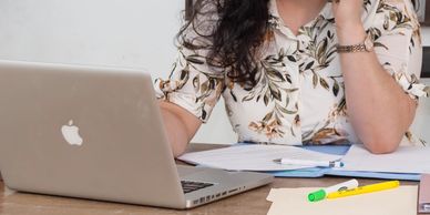 remote senior immigration paralegal communicating with clients via telephone and typing on laptop.