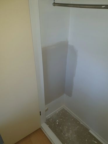 A partially painted corner wall in a room.