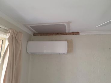 Wall with unfinished patch and air conditioner.