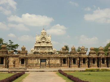 Historic stone temple with intricate carvings under a partly cloudy sky.