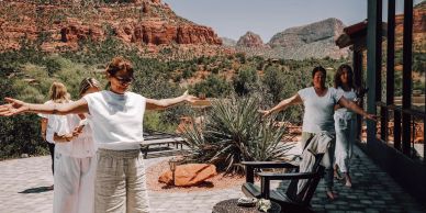 Group enjoys a sunny day with open arms in a desert landscape.