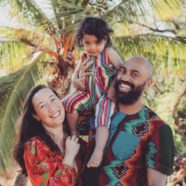 family of 3 by the palm tree