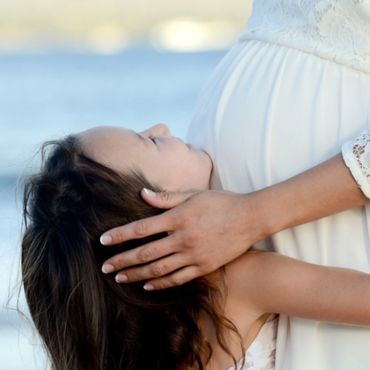 Kid kissing pregnant mother belly.