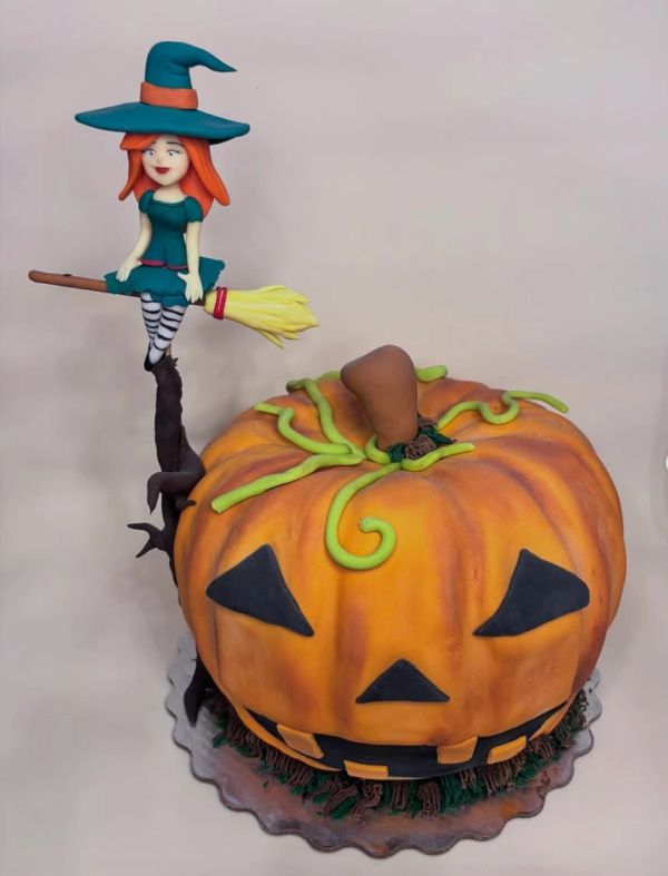 Pastel de calabaza con bruja sentado en escoba.