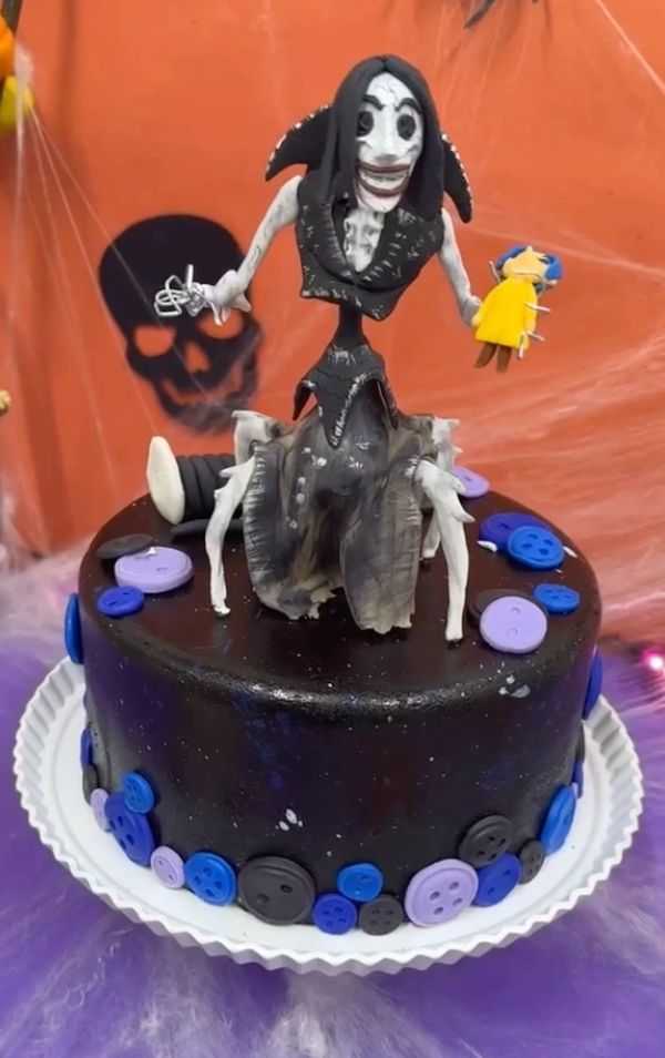 Pastel temático oscuro con figura espeluznante en la cima.