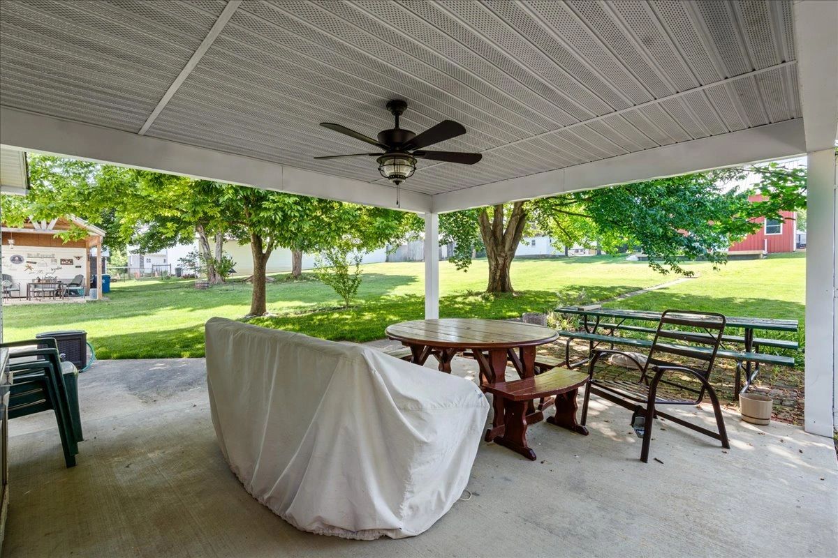 Covered patio with outdoor seating and ceiling fan.