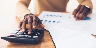 Person using calculator with financial documents.