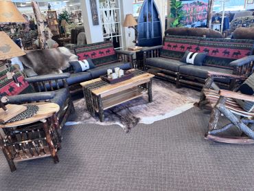 Rustic living room with log furniture and animal-themed fabric.