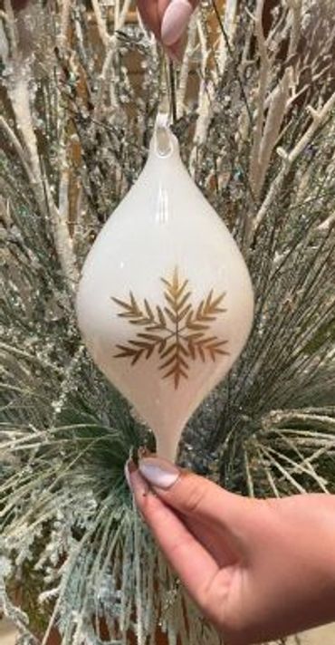 Glossy white glass ornament with embossed gold snowflake on both sides.