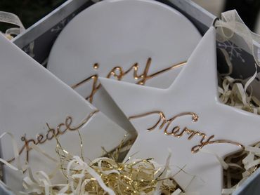 Sullivans holiday white porcelain ornaments with, peace, joy and merry in gold script.