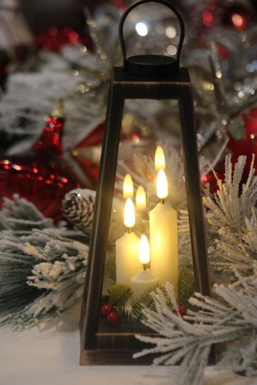Christmas lantern with lighted candles and greenery.