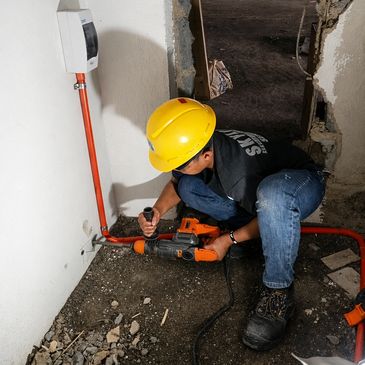People drilling a hole in the wall for elevator Installation