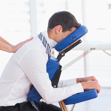 Man receiving a seated massage on a chair.