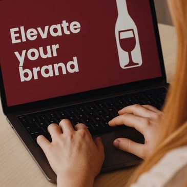Computer screen with the words "Elevate your brand" and a wine bottle with a wine glass inside it