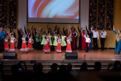 Children performing a colorful dance on stage.