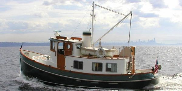 A classic tugboat sailing on calm waters with a city skyline in the distance.