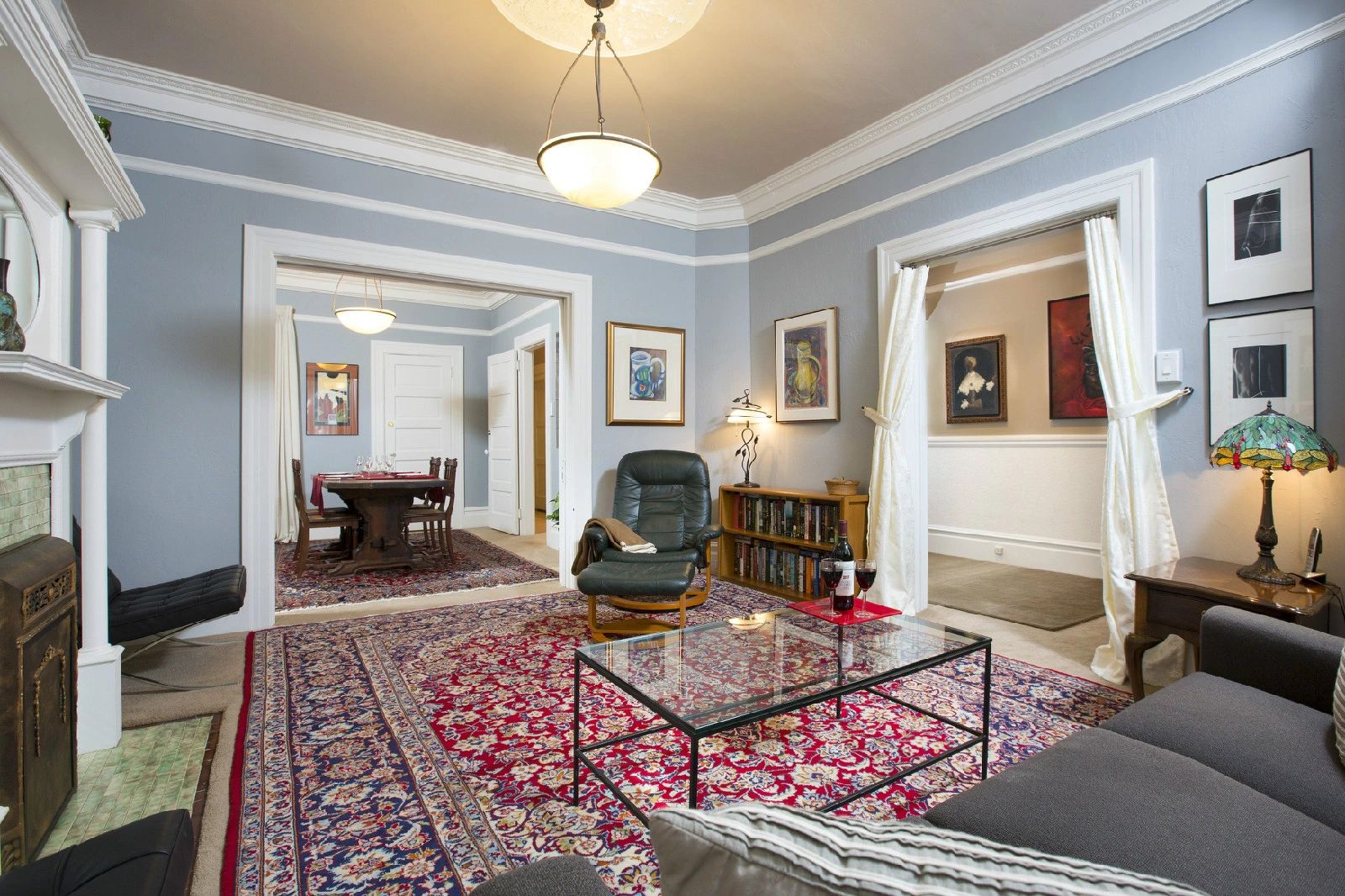 Living room looking toward dining room. Original art and oriental rugs. 