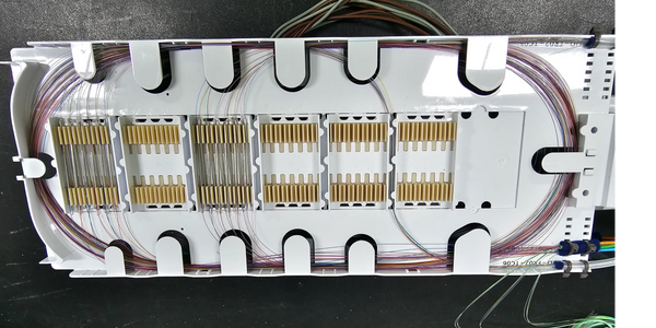 Organized fiber optic cable management tray with neatly arranged fibers and connectors.