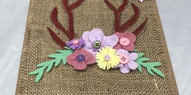 Mixed media wall art using burlap as a background, acrylic paints and pastel felt to add detail.