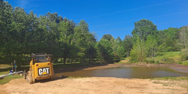 In progress of the pond drain excavation job, with Caterpillar 259B3 Skidsteer.