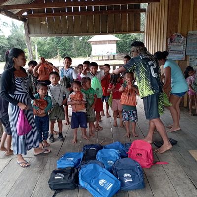 Niños reciben mochilas en una comunidad rural.