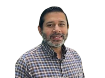 Man with beard wearing a checkered shirt smiles.