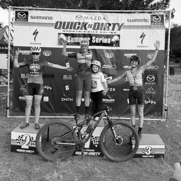 Cycling race winners on podium with a mountain bike.