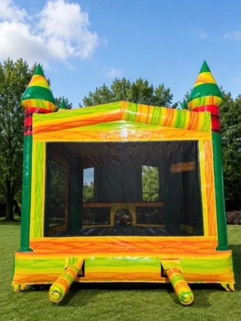 Colorful inflatable bounce house set up on green grass under a blue sky.