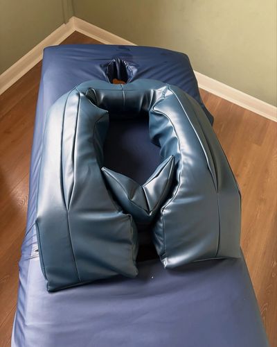Specialist Belloost front laying Pregnancy Pillow in Navy blue laid on massage couch 