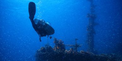 Scuba diver exploring underwater wreck.