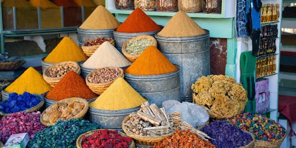 Colorful spices and dried herbs in baskets and metal containers.
