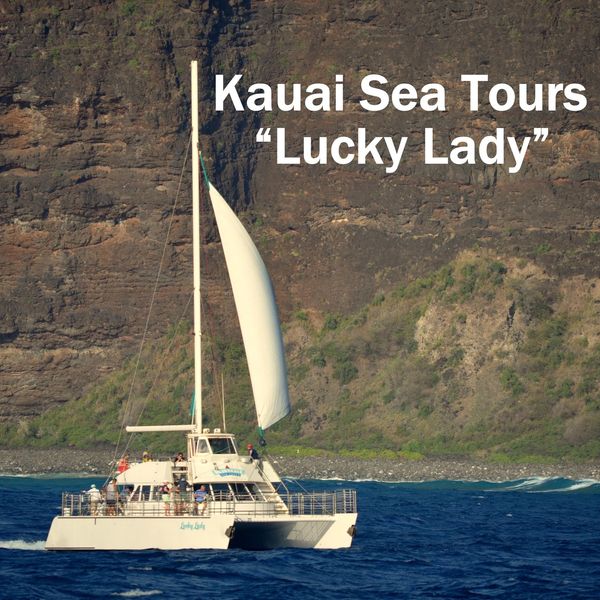 Sailboat Lucky Lady tours Kauai's coastline with passengers onboard.