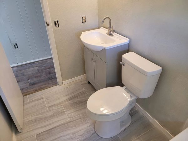  White and grey bathroom renovation with new vanity and toilet. 