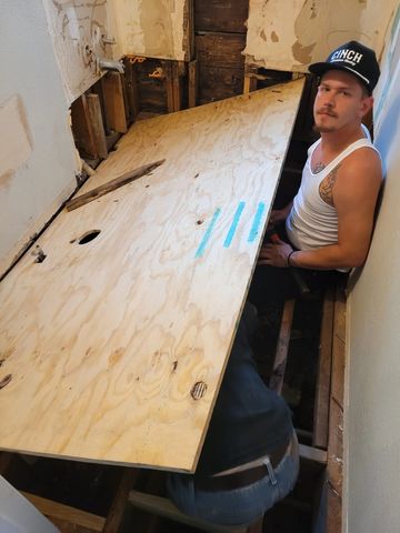 Tristan repairing subfloor in Mannford home. 