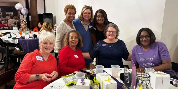 Group of women smiling at a dining table.