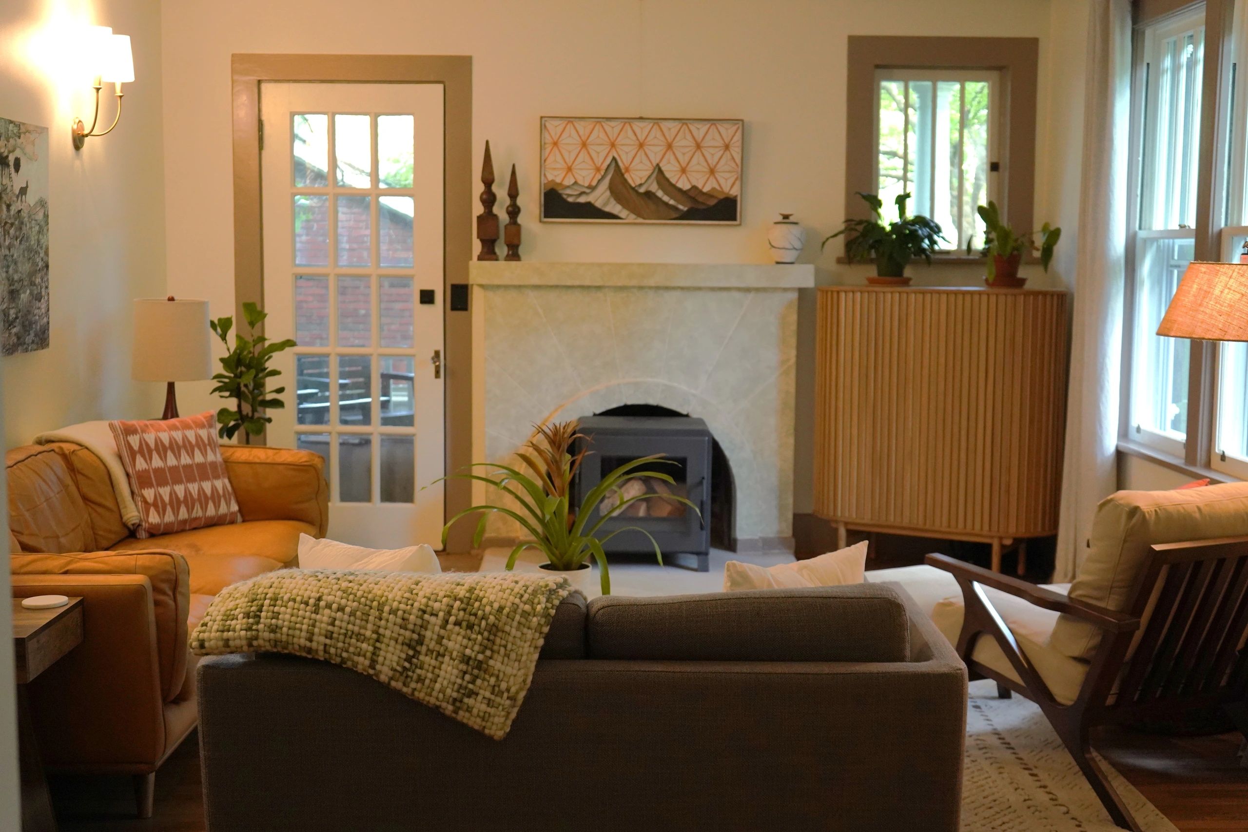 Cozy living room with warm tones and plants.