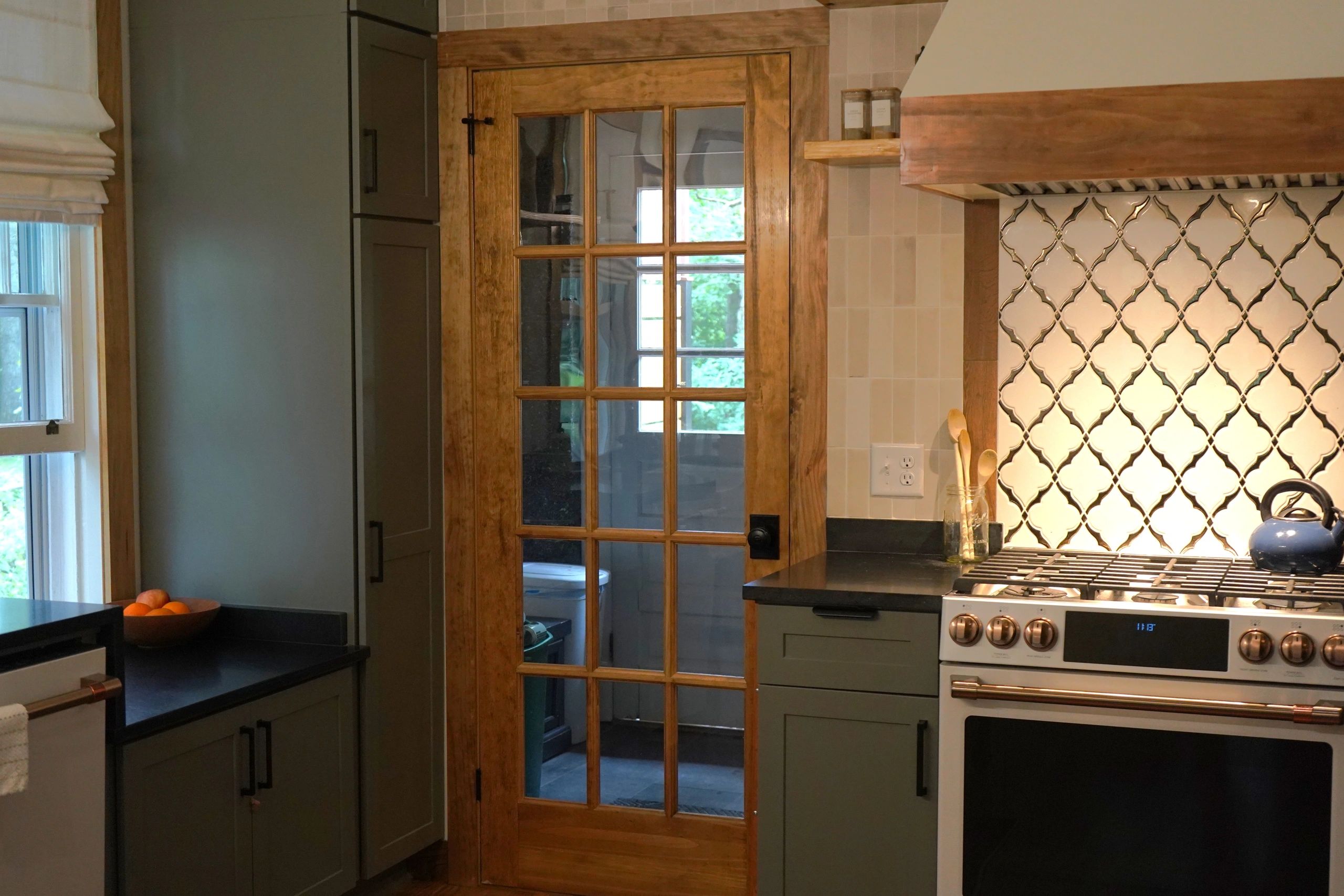 Kitchen with wooden door and modern stove.