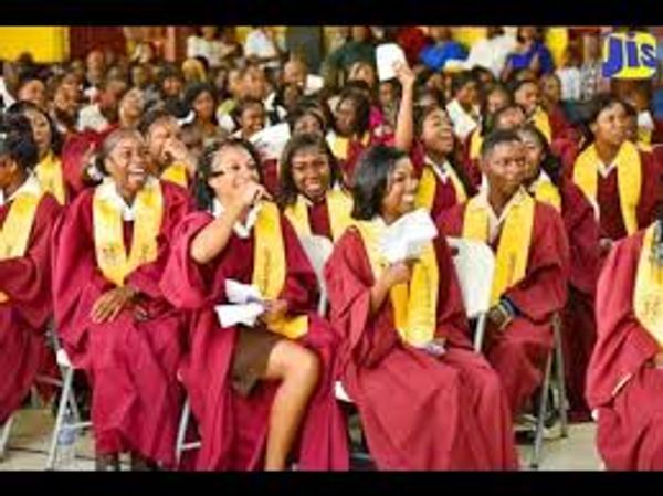 Graduates in maroon gowns celebrating.