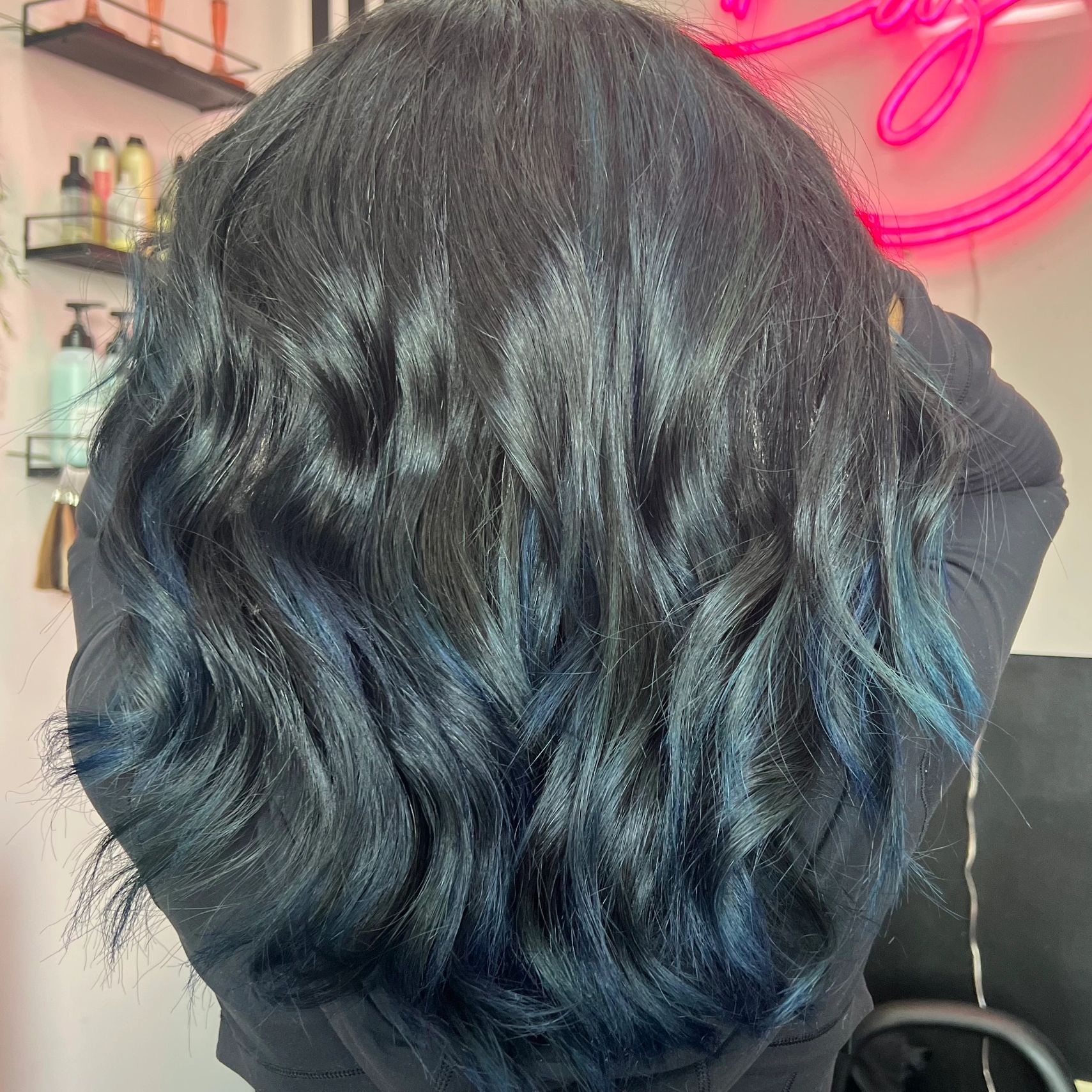 Shiny dark wavy hair with blue highlights.