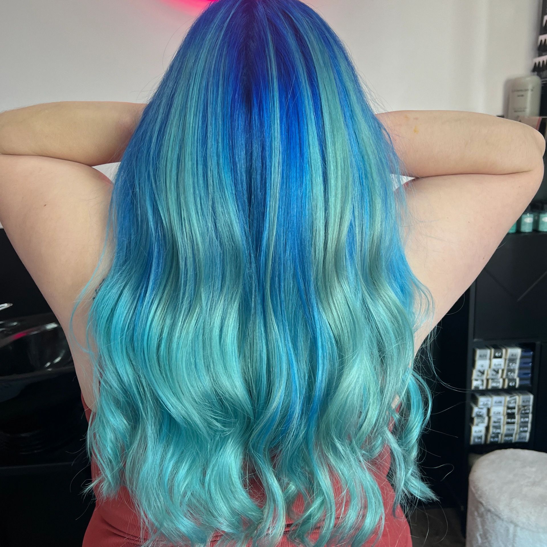 Vibrant blue and teal ombré hair from the back.