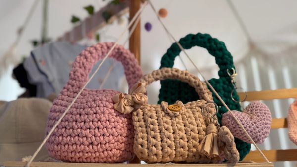 Handmade crocheted bags in pink, beige, and green colors.