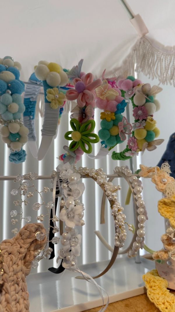 Colorful and pearl-decorated headbands displayed on a rack.