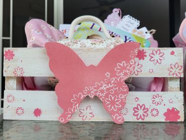 Decorative wooden crate with a pink butterfly and flowers.