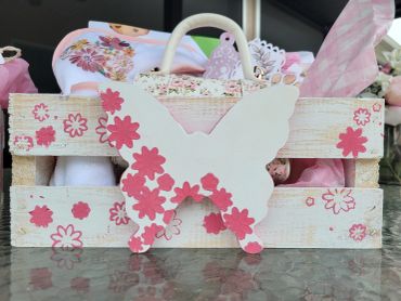 Wooden crate decorated with a butterfly and pink flowers.
