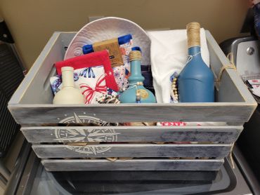 Decorative crate with bottles and fabric items.
