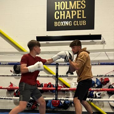 Two young men boxing in a gym.
