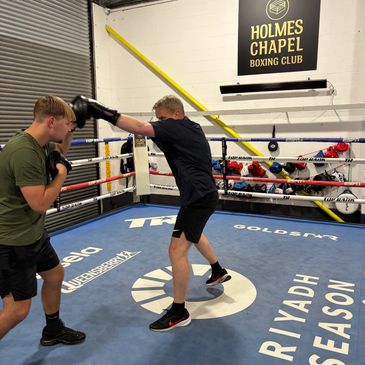 Two men boxing inside Holmes Chapel Boxing Club.