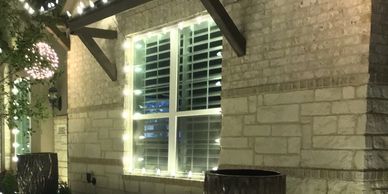 House window decorated with string lights at night.