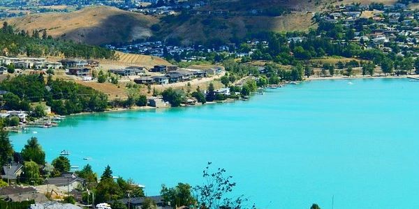A turquoise lake with hillside homes.