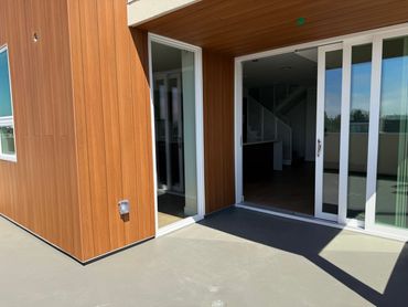 Modern balcony with sliding glass doors and wooden paneling.